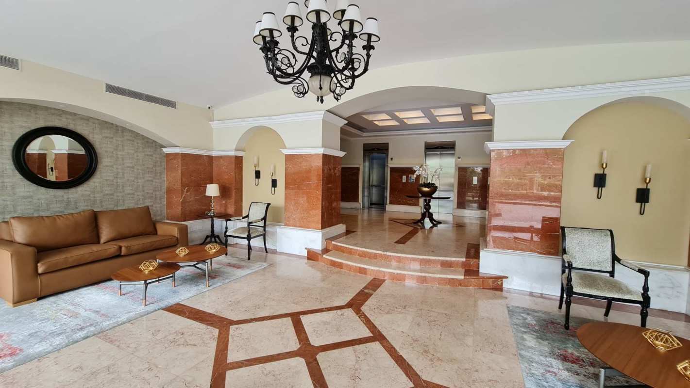Elegant building lobby with marble flooring, chandeliers, seating area in Mystic Point Punta Pacífica