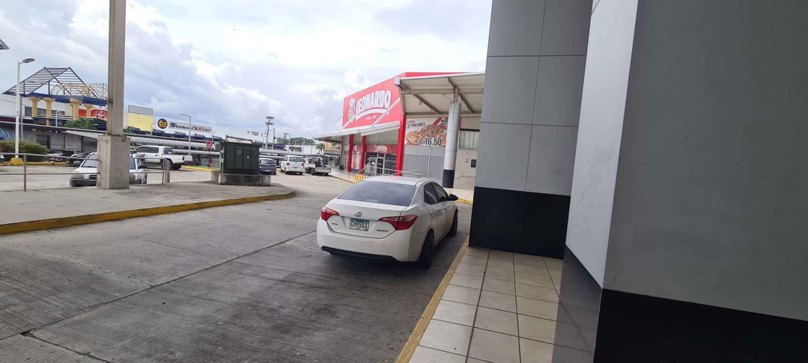 Main facade Crystal Plaza Mall with palm trees across Los Pueblos Shopping Center Panama