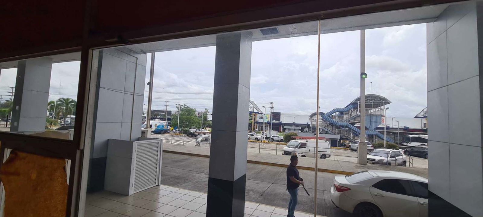 Busy avenue outside Crystal Plaza retail units with pedestrians and vehicles Panama City