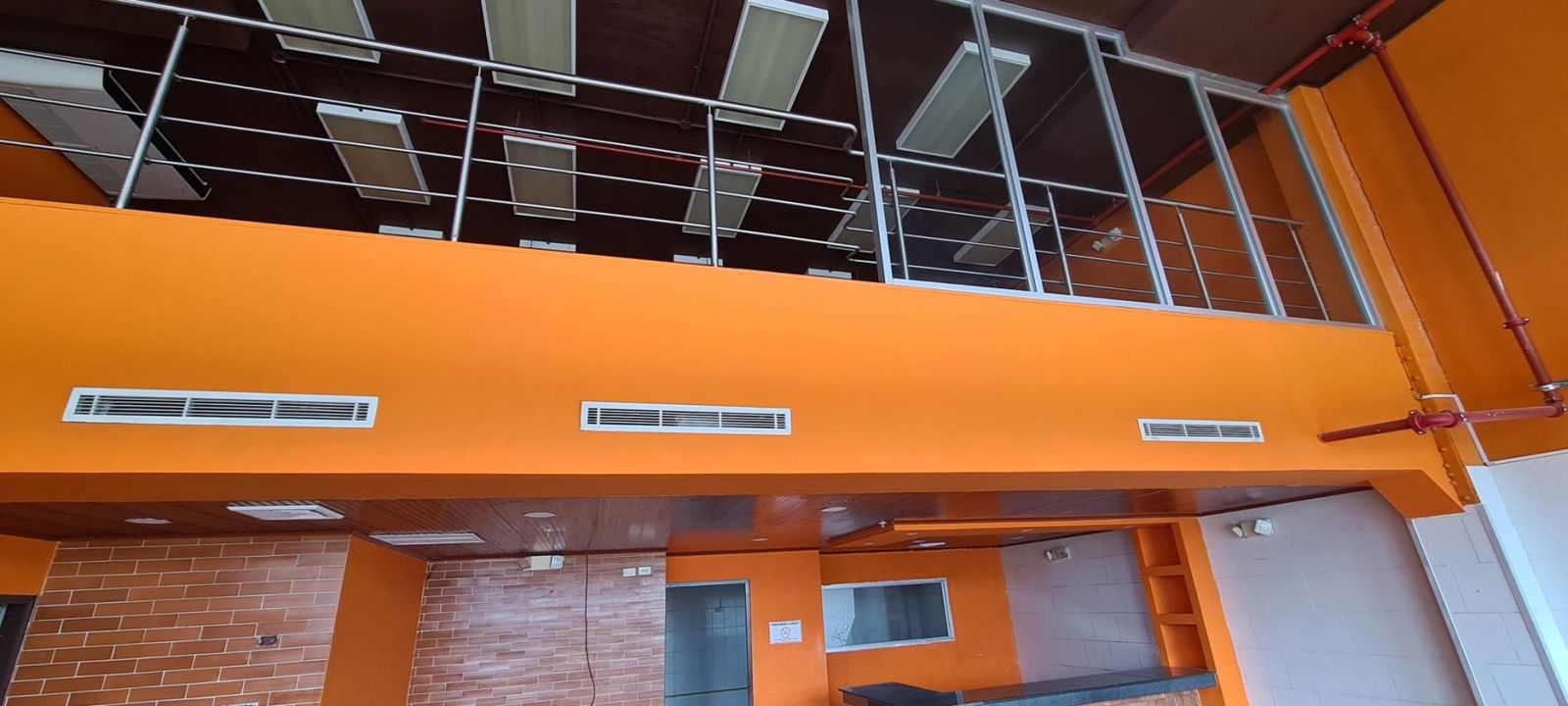 Commercial interior mezzanine level, orange walls, brick accents in Crystal Plaza retail Panama