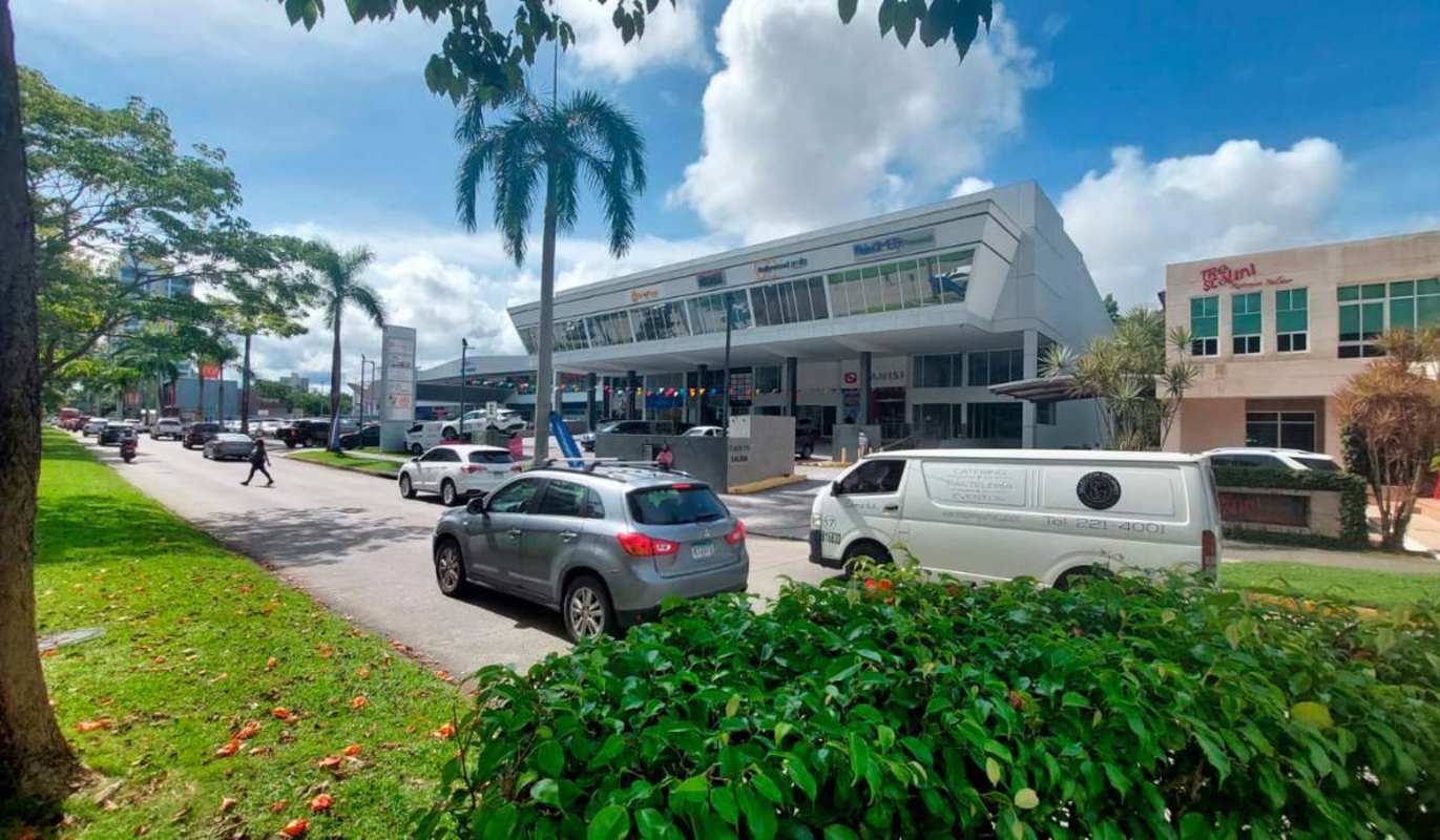 Modern commercial plaza exterior with large glass windows and parking in Costa del Este Panama