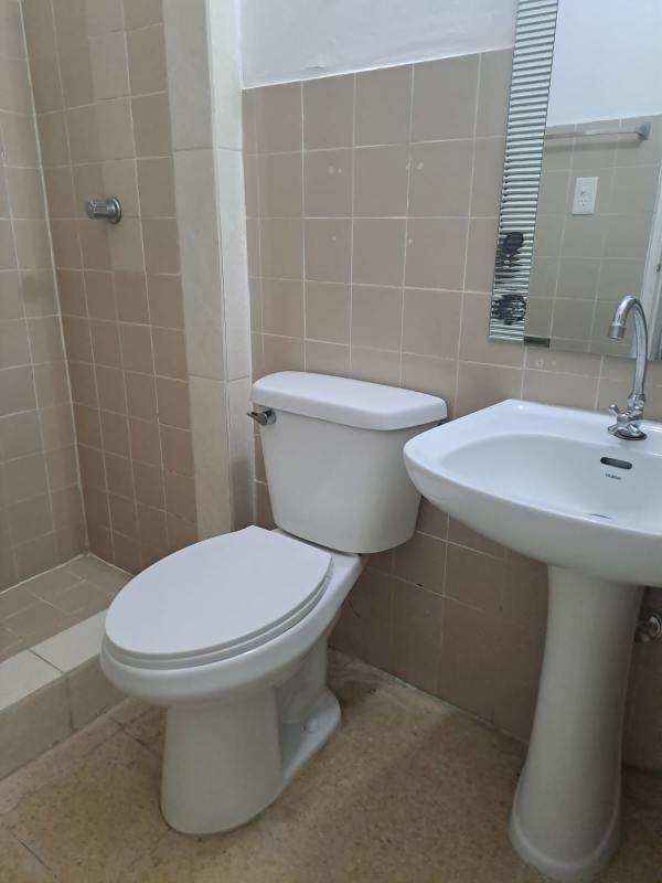 Modern bathroom with beige tiles walk-in shower and pedestal sink PH El Carmen Towers Panama