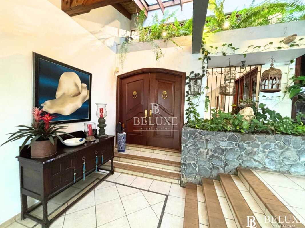 Swimming pool and jacuzzi surrounded by gardens at luxury house in Altos del Golf Panama