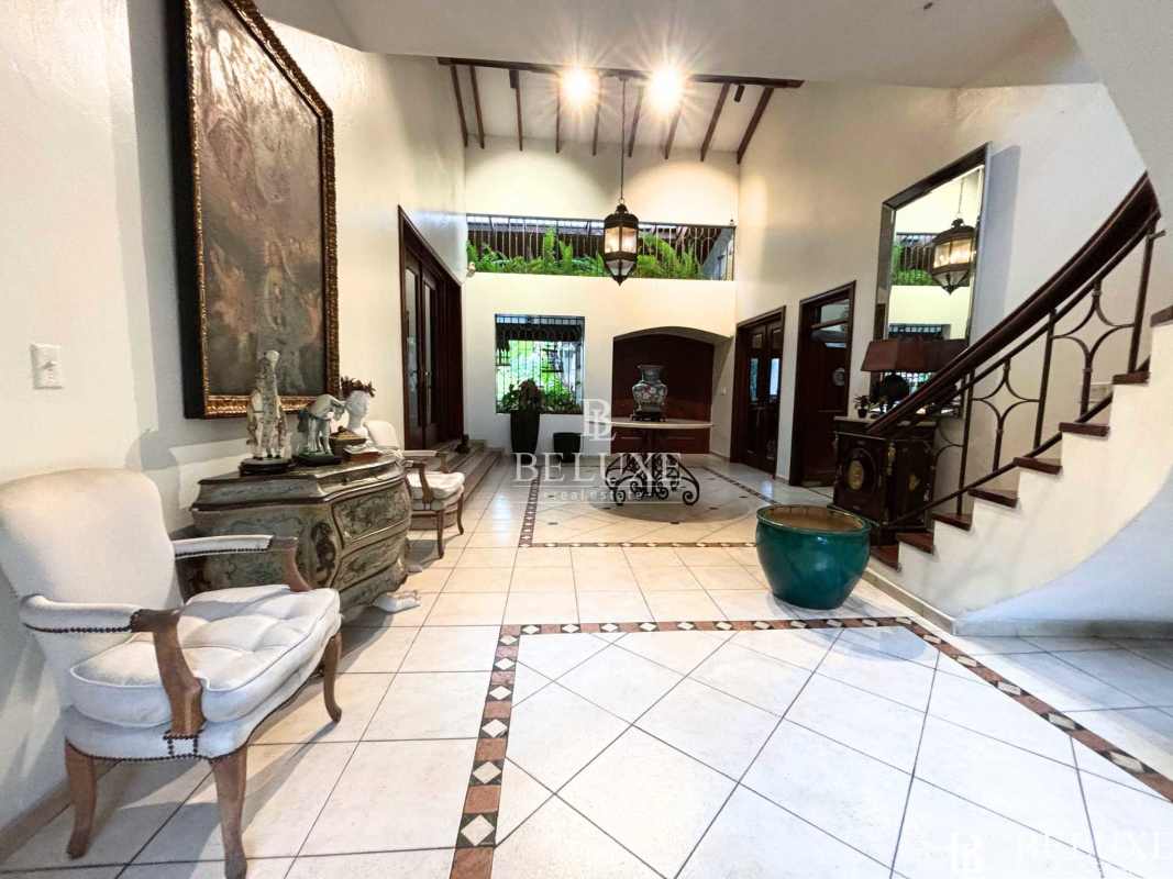 Traditional entrance hall with grand staircase and Mediterranean design at Altos del Golf