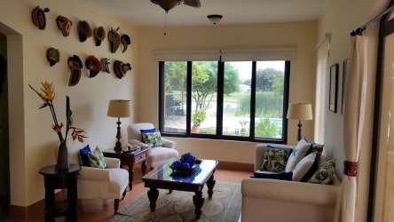 Bright living room with traditional decor, outdoor garden view, ceiling fan in villa Buenaventura Panama