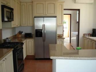 Traditional kitchen with granite counters, kitchen island, stainless appliances in villa Buenaventura Panama