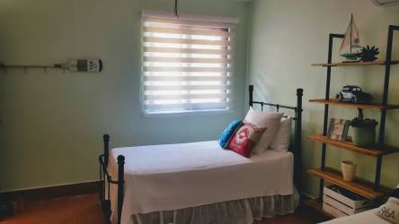 Bright master bedroom with vaulted ceiling, balcony access, and lake view in luxury beach villa Buenaventura Panama