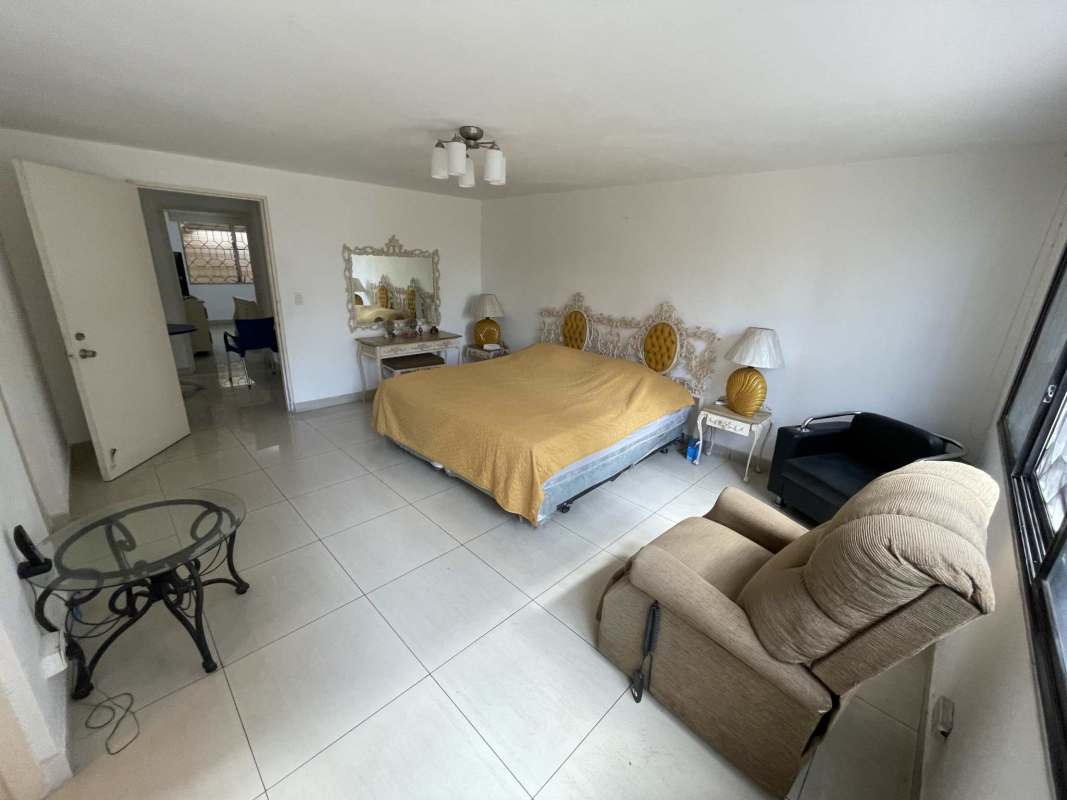 Master bedroom with vintage decor, recliner chair and large windows PH Monaco Panama