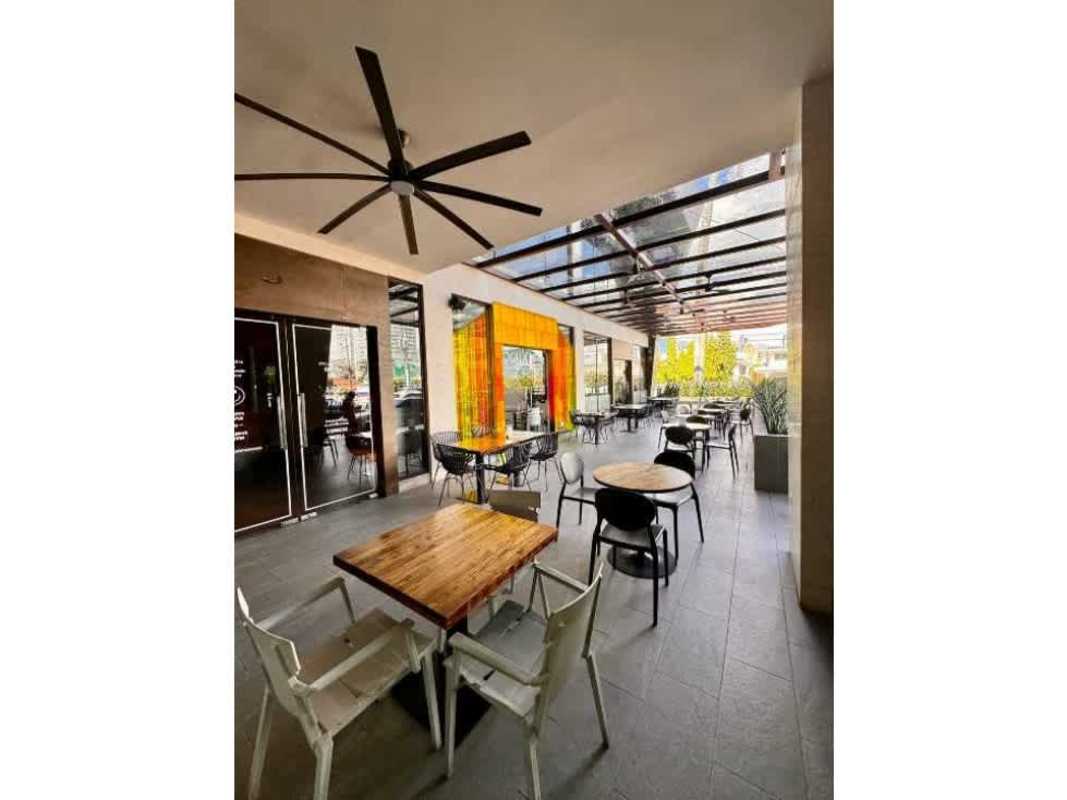Large covered outdoor seating area with glass roof and urban surroundings at Plaza Corne 68 Panama City