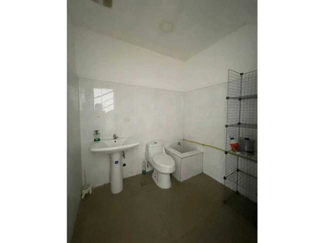 Bathroom with pedestal sink, toilet, utility sink, shelving in commercial property Plaza 68 Panama
