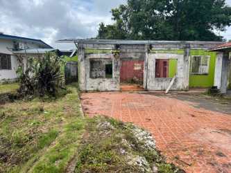 Abandoned concrete structure with yard, tiled drive, overgrown vegetation Paso Canoas Chiriquí