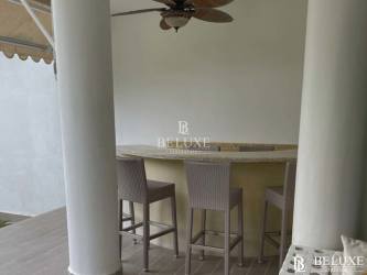 Contemporary dining area with glass table and accent wall in Bijao beachfront condo