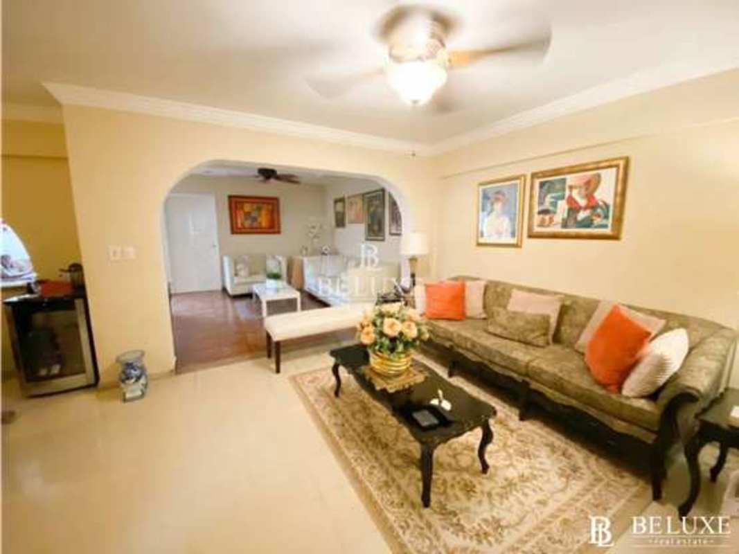 Living room with cream sofa, archways, artwork, tile floors in Bethania Panama house sale