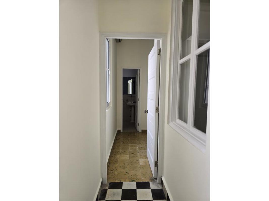 Hallway with checkered tile floor leading to bathroom in colonial penthouse Casco Viejo Panama