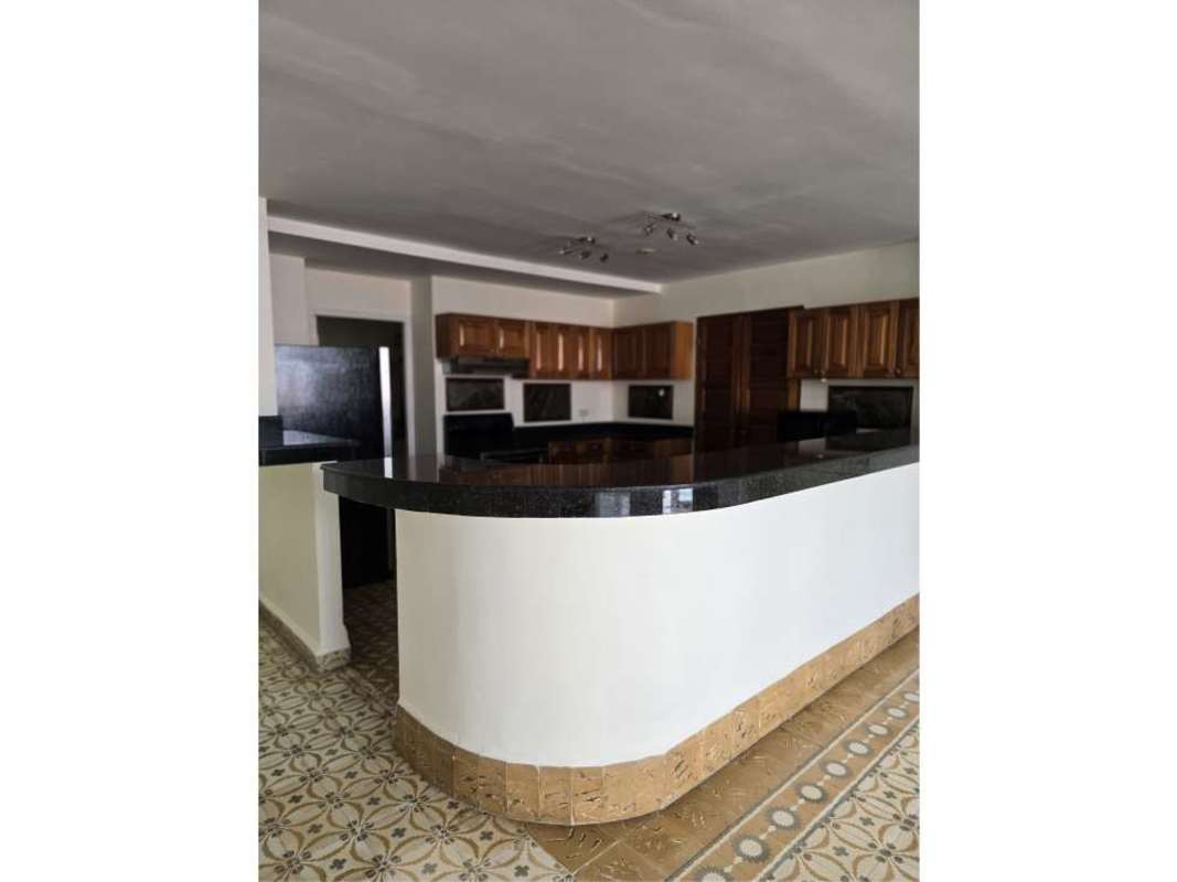 Living space with checkered black and white floor, high ceiling, tall windows in Casco Viejo loft Panama