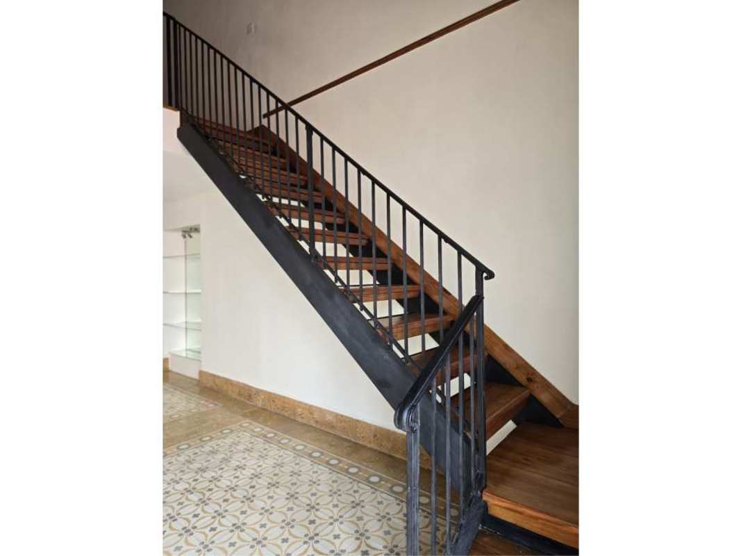 Interior wooden staircase with metal railing and glass shelves in Casco Viejo colonial penthouse Panama