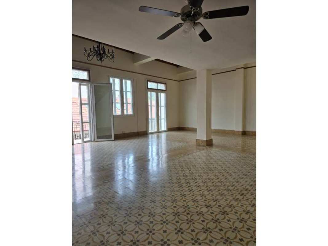 Spacious colonial living room with decorative tile floor, tall windows in Casco Viejo luxury loft Panama