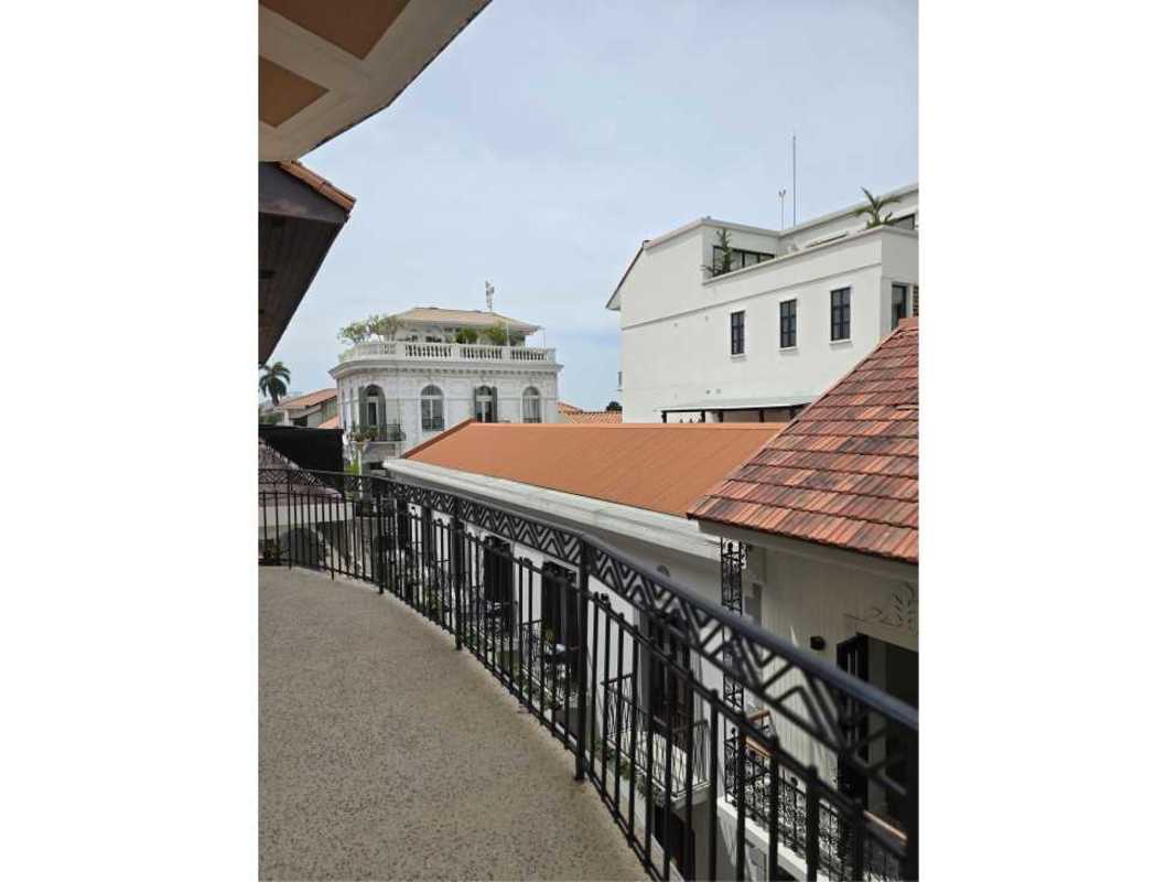Balcony overlooking Mediterranean colonial buildings with terracotta roofs and gardens in Casco Viejo Panama