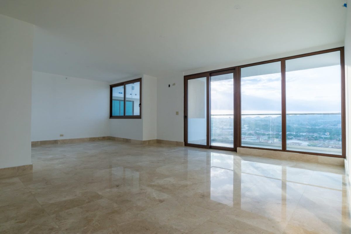 Open concept living and dining area with marble flooring and large windows at PH The Colonial Panama