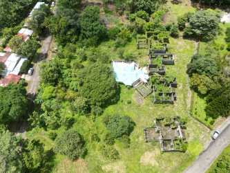 Top-down view showing overgrown vacant land with abandoned structures in Dolega Chiriquí