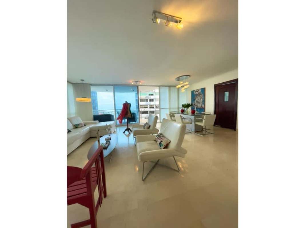 Spacious open-plan living room with marble floors and ocean view balcony at Vista del Sol Punta Paitilla Panama