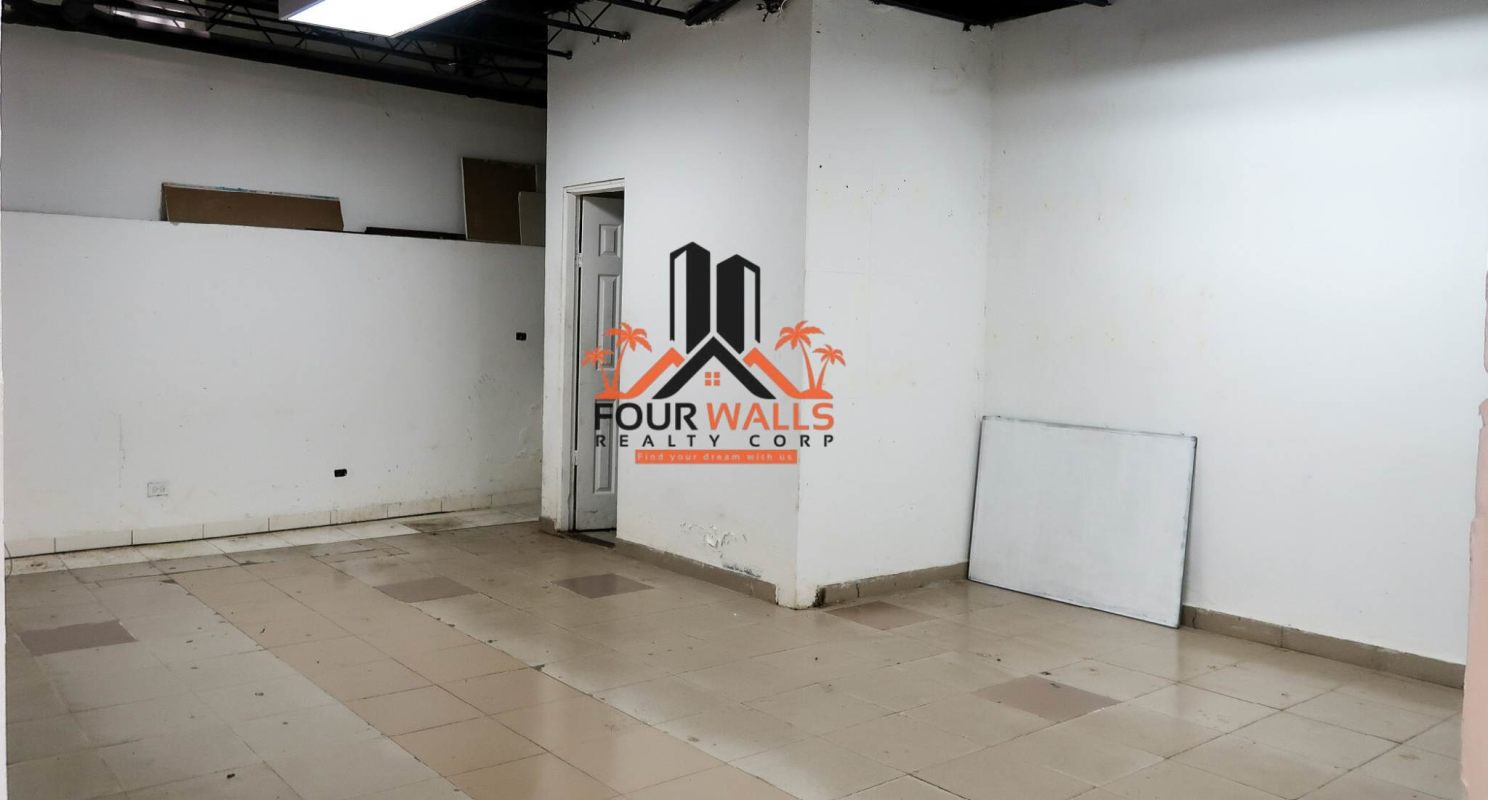 Empty open office space with white walls tiled floors chairs and cubicles Plaza Los Colores Panama City
