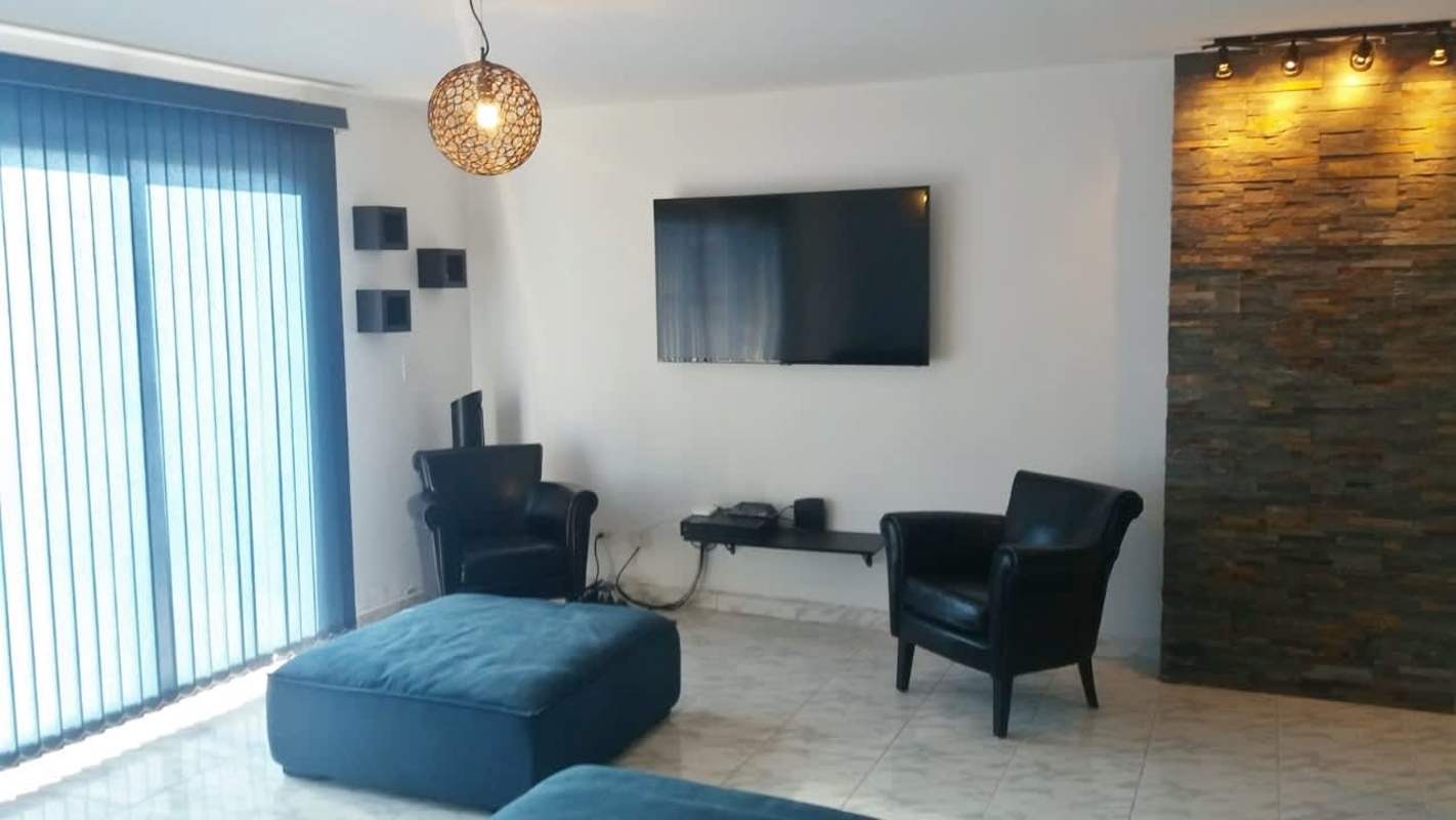 Open-concept living room with sectional sofa, marble flooring, air conditioning at PH Parque Lindo