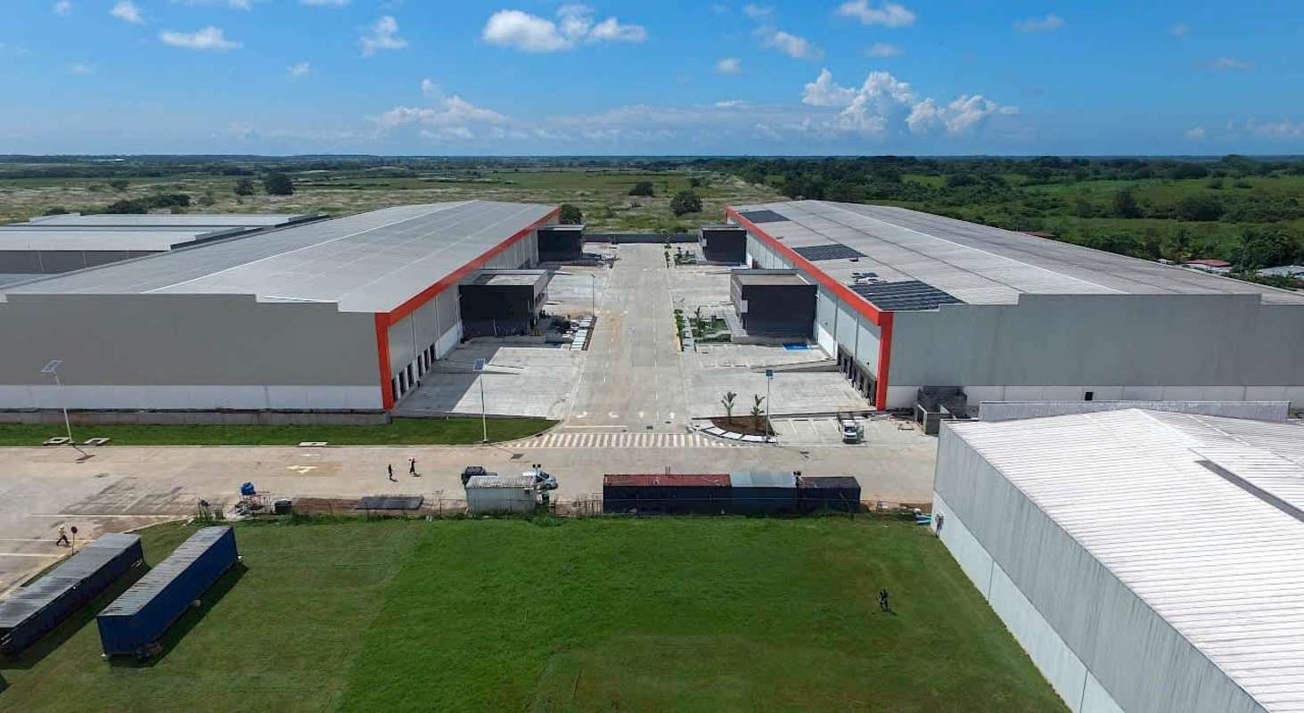 Aerial panorama of industrial warehouses and infrastructure bordered by vegetation in Panama Free Zone