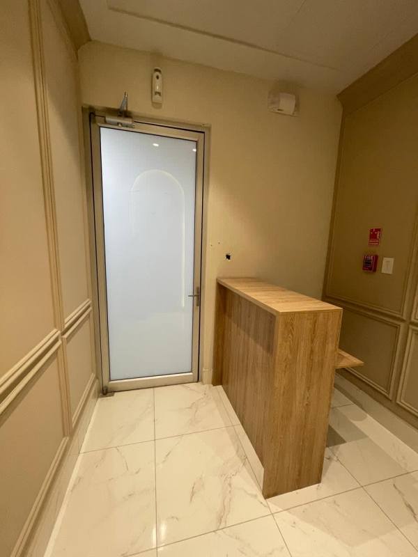 Modern reception with wooden desk, marble tile and frosted glass door in Town Center Costa del Este Panama
