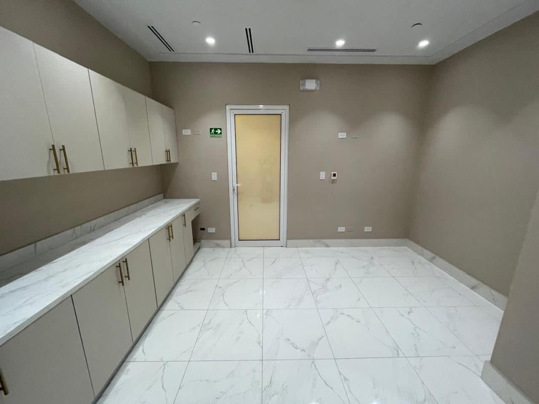 Modern utility room or kitchenette with marble style countertop and beige cabinetry in Town Center Costa del Este Panama
