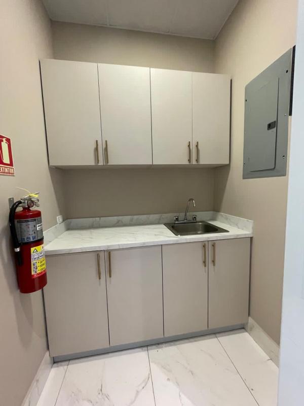 Small kitchenette with beige cabinets, marble countertop and sink in Costa del Este Panama