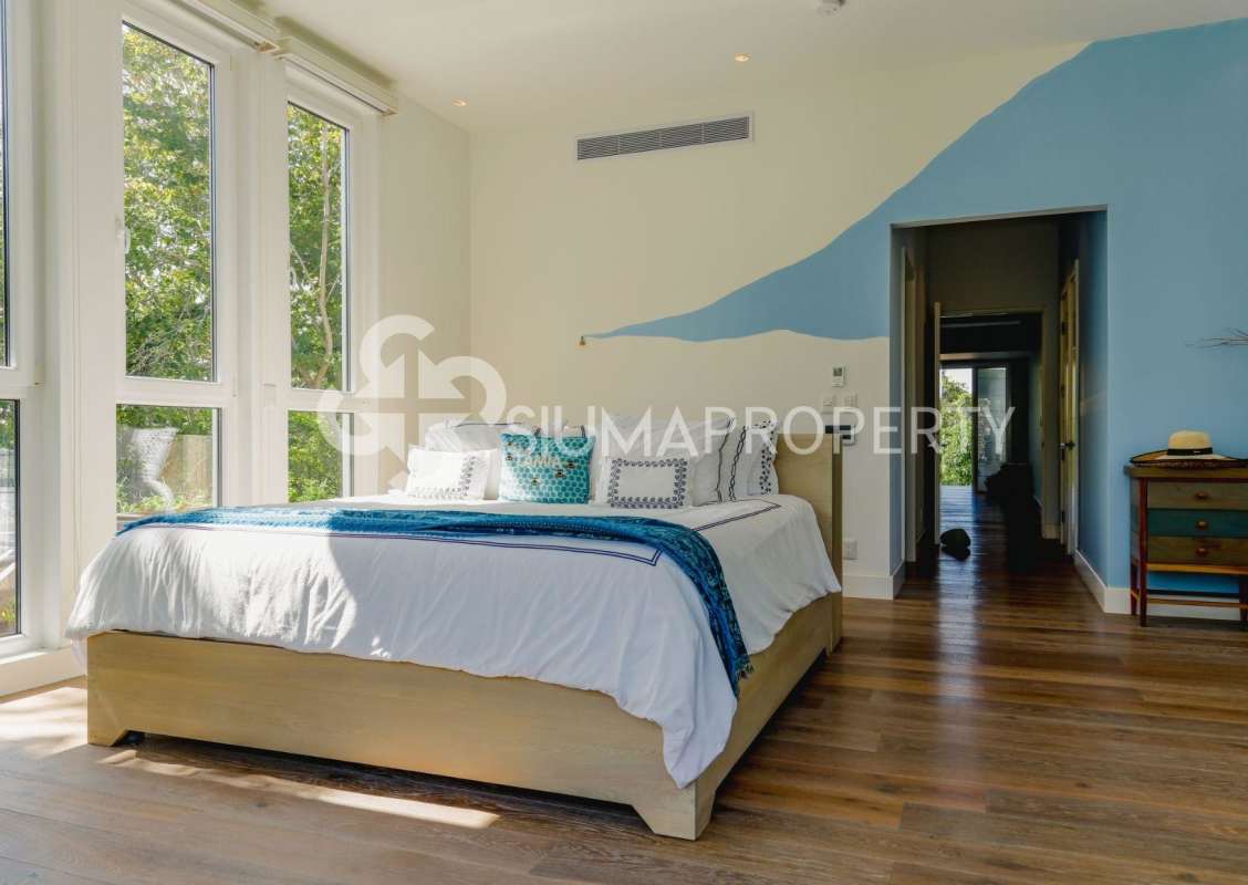 Sunny bedroom with pastel green walls, twin beds, natural light in Pearl Island Panama