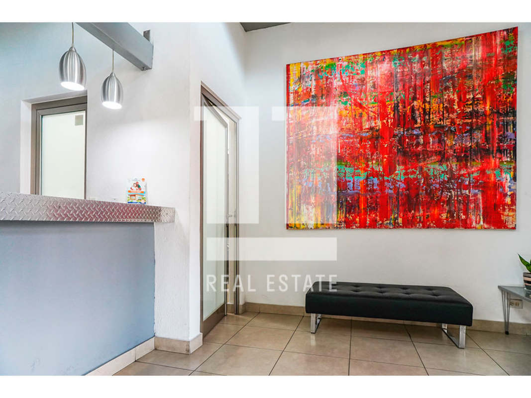 Reception area with colorful artwork, metal counter, on Calle 50 Panama City