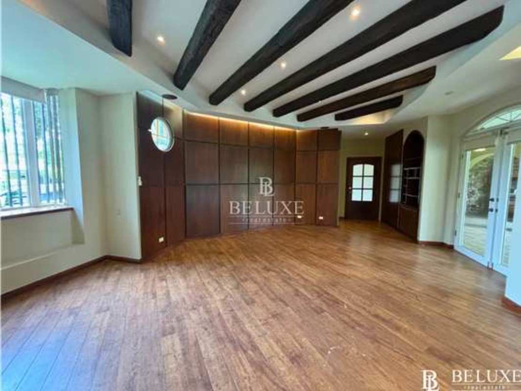 Elegant entryway with stone accent wall and solid wood staircase in Altos del Golf luxury house Panama City