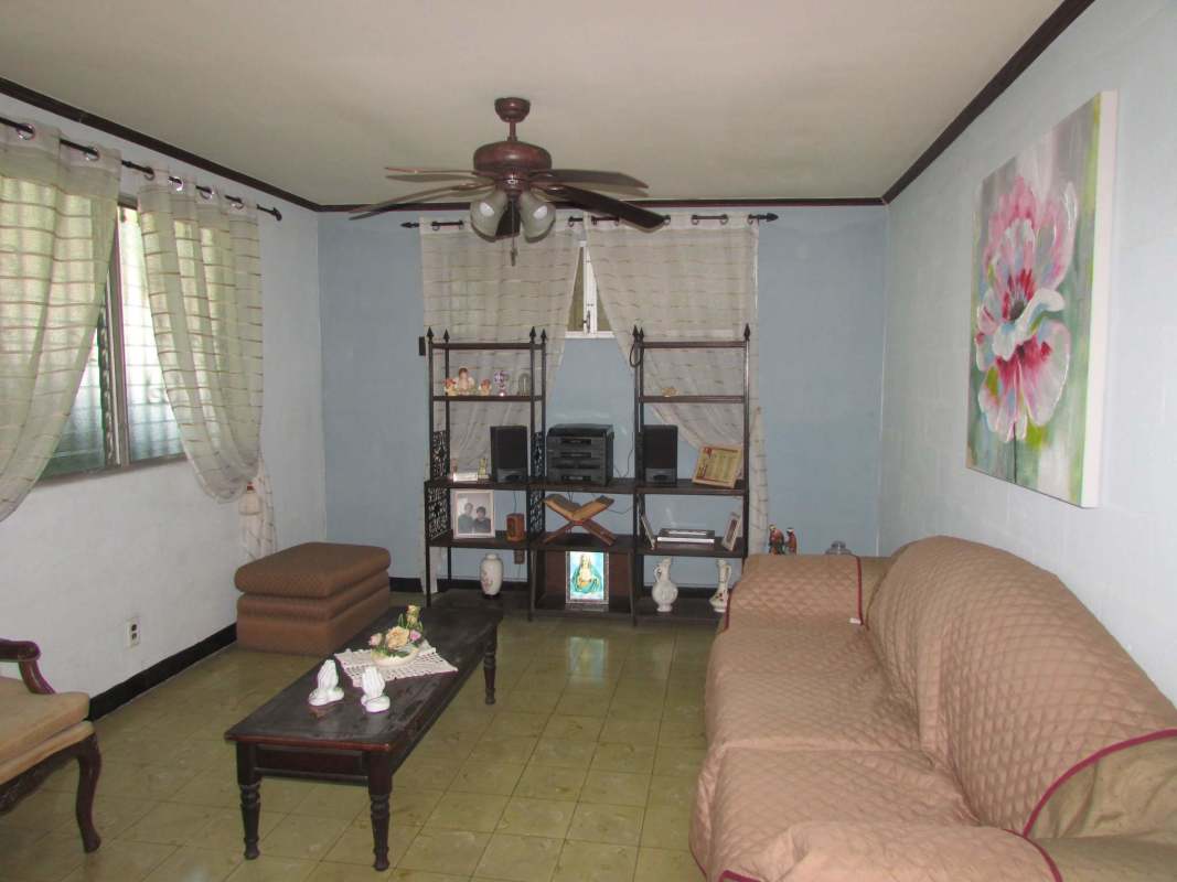 Gated carport patio with concrete floor yellow walls in Pedro Miguel house Panama