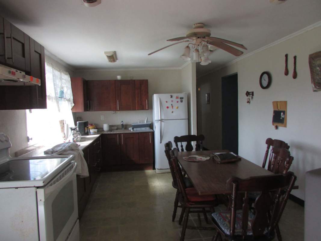 Spacious kitchen with wooden cabinets and dining area Pedro Miguel house Panama