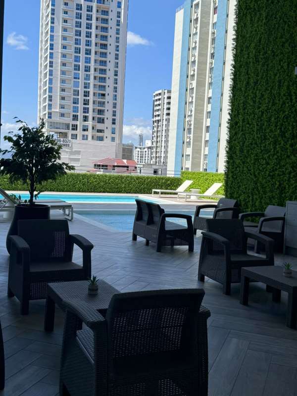 Outdoor swimming pool area with lounge and city skyline high-rise PH Centerpoint 12 de Octubre