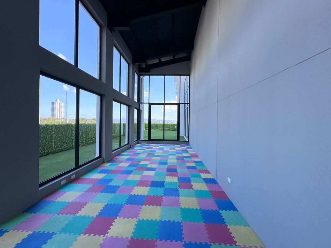 Bright children's playroom with colorful foam mat and glass wall views at PH Centerpoint Panama City