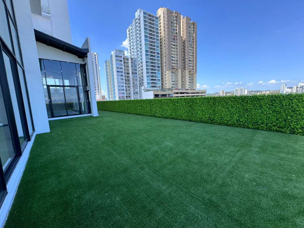 Rooftop terrace with artificial grass, privacy hedge, and skyline views at PH Centerpoint Panama