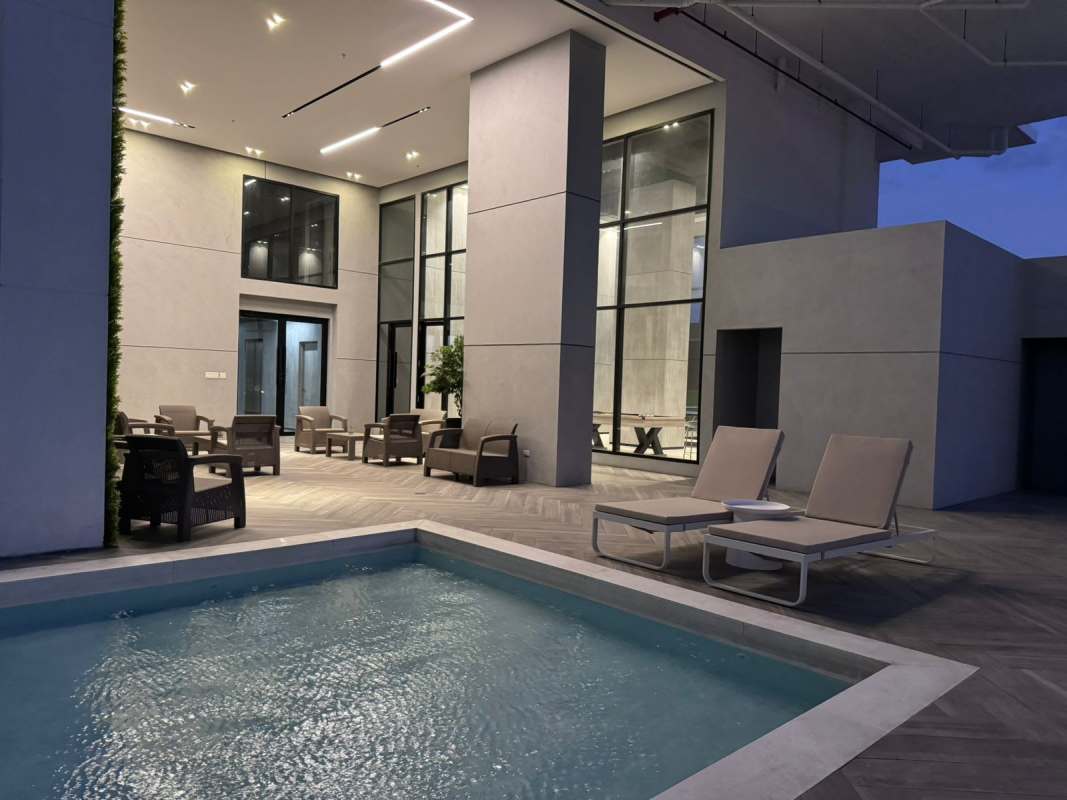 Outdoor lounge by swimming pool at night with city view PH Centerpoint Panama
