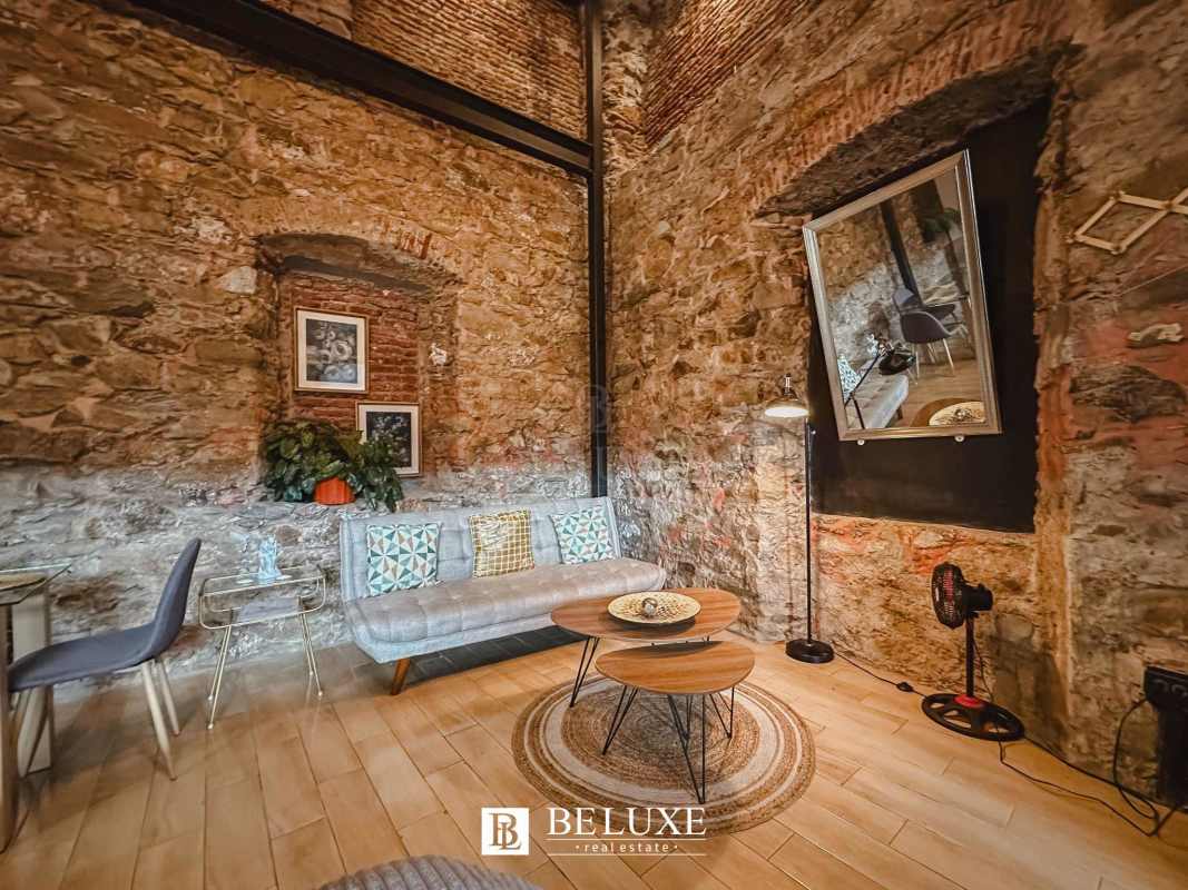 Rustic living room with exposed stone wall wood floors sofa PH Casa Santana Panama