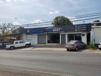 Streetfront commercial spaces with parking and signage along Avenida Libertador La Chorrera Panama
