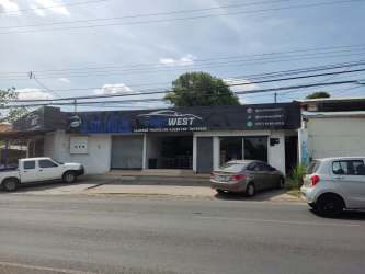 Wide-view exterior of retail property with glass storefront, parking and sidewalk on Avenue Libertador in Costa Verde, Panama
