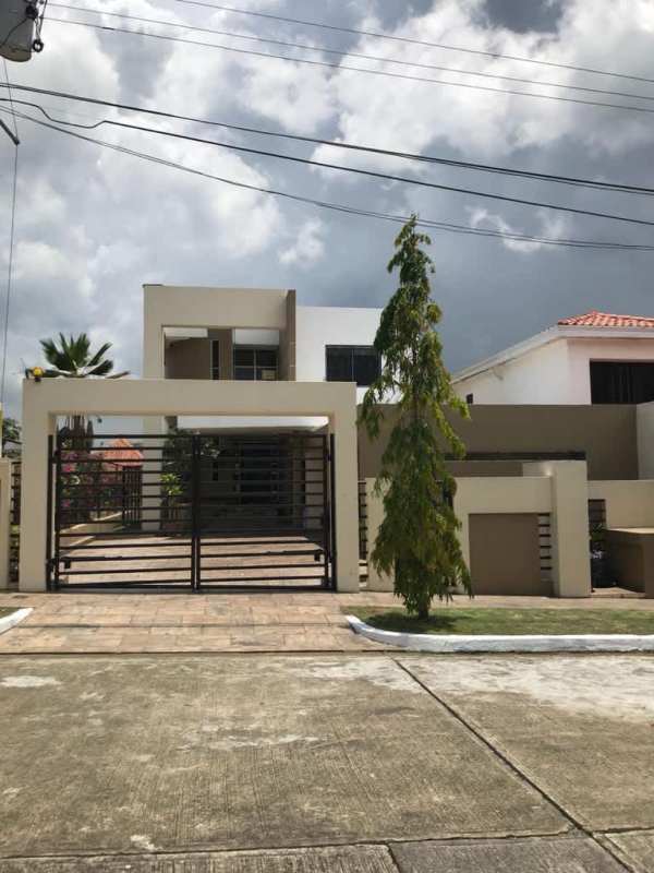 Large bright bedroom with floor-to-ceiling windows, wooden floors, king bed, and greenery view in house at Altos de Panamá Panama