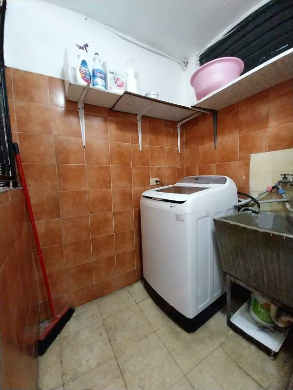 Laundry room with washing machine, sink and storage shelves Panama apartment