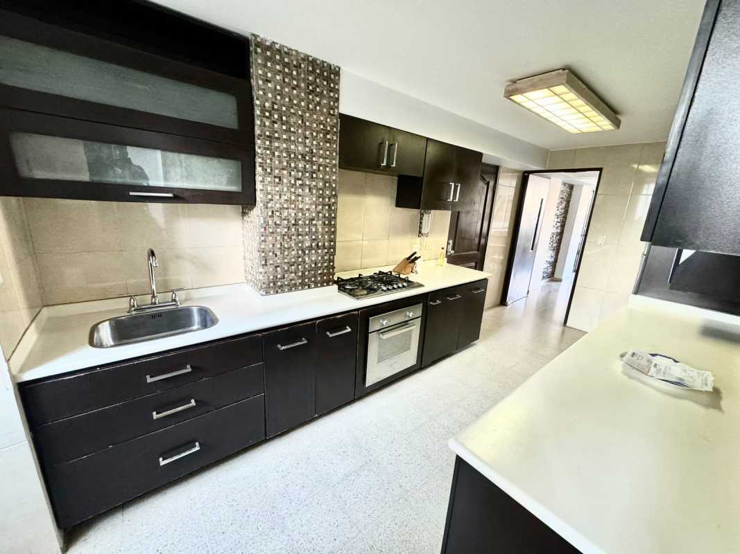 Kitchen with gas cooktop, dark cabinetry, mosaic tiles PH Arcelia Bella Vista Panama City