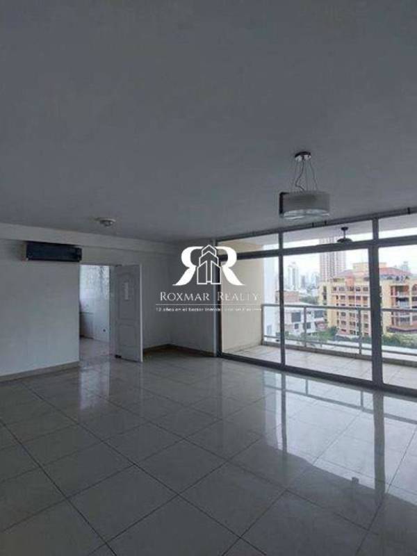 Spacious living room with floor-to-ceiling windows and city skyline view in PH El Cangrejo Suites Panama City