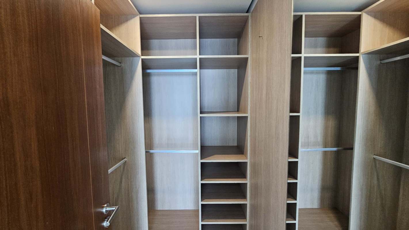 Large light wood walk-in closet with built-in storage in PH Parkside Costa del Este Panama