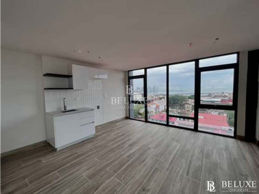 Open concept living and dining space with floor-to-ceiling windows in Casco Viejo apartment Panama