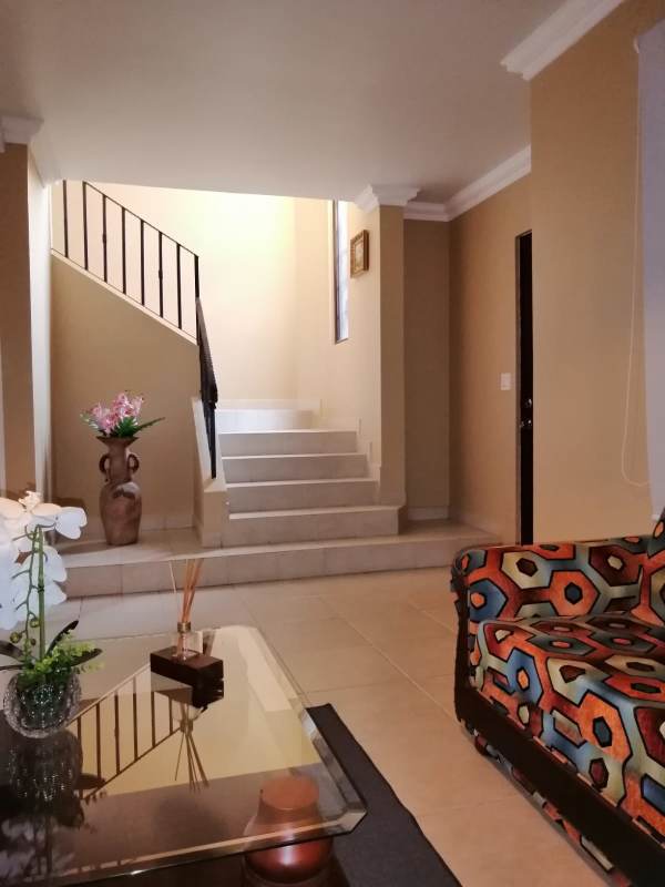 Two-story living room view with stairs in PH Versalles Costa Sur Panama